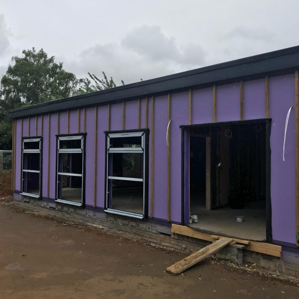 Applying fibre-reinforced Passive Purple airtight coating to ensure ultra-low air change rate at Passivhaus school project.